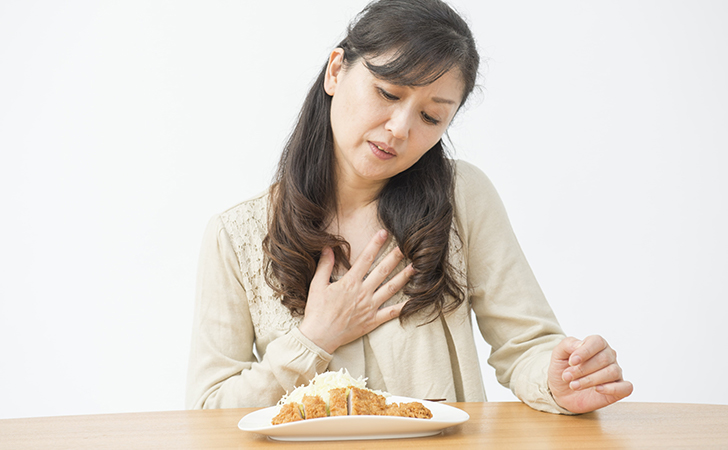 胃もたれしている女性